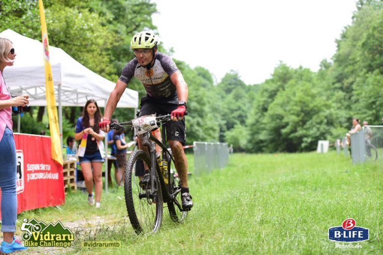 Vidraru Bike Challenge 2019 | Ediția 6, proaspat incheiat, in sfarsit am avut ocazia sa particip, la tura lunga de 90 km cu 2.400 diferenta de nivel. Se pare ca noua paradigma de abordare a curselor, in care vreau sa savurez actiunea fara stresul podiumului, functioneaza! Cred ca de aceea mi-am luat si baggys Cannondale! :D Am ajuns la barajul Vidraru pe asfalt, impreuna cu primul grup, apoi am continuat intr-un ritm bun in off-road, fiind undeva in primii 15 la general. Nu am putut duce ritmul lui Vlad Urzica, care parea sa aibe probleme cu tubeless-ul, pentru ca l-am gasit de doua ori pe traseu m-am multumit sa-i apreciez din spate tehnica de pedalat. Am constatat ca am un "gremlin" pe care daca il stresez cu faze gen "nu te lasa, da tot ce faci", el se supara si ma face sa merg mai rau, in schimb daca il las in pace, acest gremlin imi da el bice sa merg mai repede. Ceea ce s-a intamplat pe lunga urcare spre kilometrul 50, unde doar spre sfarsit am fost ajuns, spre surprinderea mea de riderii de la HPM si de puternicul Romulus Vesteman. Am reluat insa ritmul si am reusit sa ma mentin, simtindu-ma foarte fresh, probabil de la aerul rece. Pe coborari, lucrurile nu s-au intamplat insa asa cum mi-as fi dorit, ceea ce nu m-a scos din zen insa. De dimineata constatasem ca am furca prea moale, lucru care s-a simtit imediat, dupa 2-3 bottom out, din care unul a rezultat in prelungite manevre de salvare, a trebuit sa o las mai moale, pentru a proteja furca, pierzand cateva pozitii. Totusi, inca in valonatul de pe creste, riderii erau in raza vizuala si reuseam sa ma apropii. Din pacate, la intersectia cu traseul mijlociu, fabulosul SRAM Eagle NX o fi simtit ca planific sa il inlocuiesc noul X12 de la Shimano, pentru ca s-a gandit sa arunce lantul de pe o rotita de la patina, trebuind sa ma opresc, bla, bla, sa trag de el, dar tot nu m-am enervat, in schimb am pierdut gremlinul care imi dadea flow. Am mai pierdut si o pozitie in fata lui Razvan Jipa, care din ce vad in clasament s-a tot dus si i-a depasit si pe cei din fata. Pe segmentele de coborare care deveneau din ce in ce mai dese am fost hartuit putin de un full, ceea ce deschide un nou capitol, poate mi-ar fi si mie bun un full! :))) Apoi, pentru ca urma un valonat, am aplicat tot ce am stiut sa ma distantez, in vederea coborarii finale si credeti-ma sa putea castiga viteza la iesirea din viraje......Auzisem ca traseul de la VIdraru nu e greu, nu e tehnic, dar in opinia mea, daca mergi tare, devine tehnic si greselile la astfel de viteze mari pot avea consecinte foarte grave. A propos de asta, ati observat cred ca am evitat sa fiu moralist si sa fac tam-tam cu treaba asta cu MTB coaching-ul dar am vazut multa lume pe traseul mijlociu, care, neadaptand pozitia corecta pe coborare, se expunea constant riscurilor unei cazaturi. A propos de coborare, aceasta mi s-a parut foarte solicitanta, imi spuneam in mod constant sa privesc mai departe, mai in fata, ma luptam in mod constant sa inclin bicicleta sub mine, au fost cateva momente ciudate, in care geometria lui F-SI4 m-a facut sa scot piciorul ca la motocross, dupa aceasta cursa mi se pare o bicicleta care la viteze mari trebuie pilotata cu o mana foarte puternica, ceea ce a facut lucrurile cu atat mai interesante. Sau am nevoie de mai multe curse cu ea. Sunt foarte multumit si asta cred ca spune ceva, deoarece singurele mele experiente pe MTB din acest sezon au fost cele trei MTB Skills and Boot Camp, in rest m-am antrenat in exclusivitate doar pe sosea. Am incheiat pe pozitia 22 la general si pe 6 in clasamentul amatorilor licentiati FRC, iar aceasta imagine, singura pe care am gasit-o dintr-un album care ar fi trebuit sa fie plin de poze din peisaje macar spectaculoase e taman de la finish.:)))